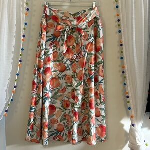 A casual maxi skirt with floral peaches on it. Bow tie in the front.